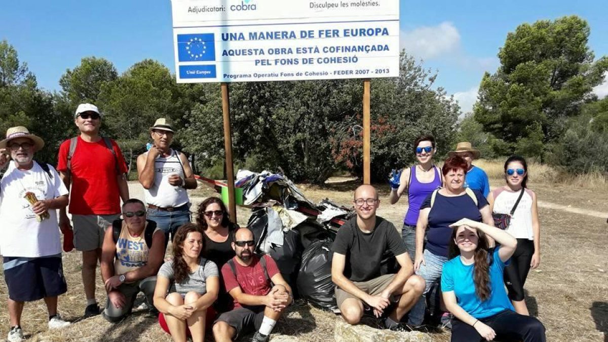 Imatge de l'equip que va realitzar la batuda de neteja amb les bosses d'escombraries al darrera.