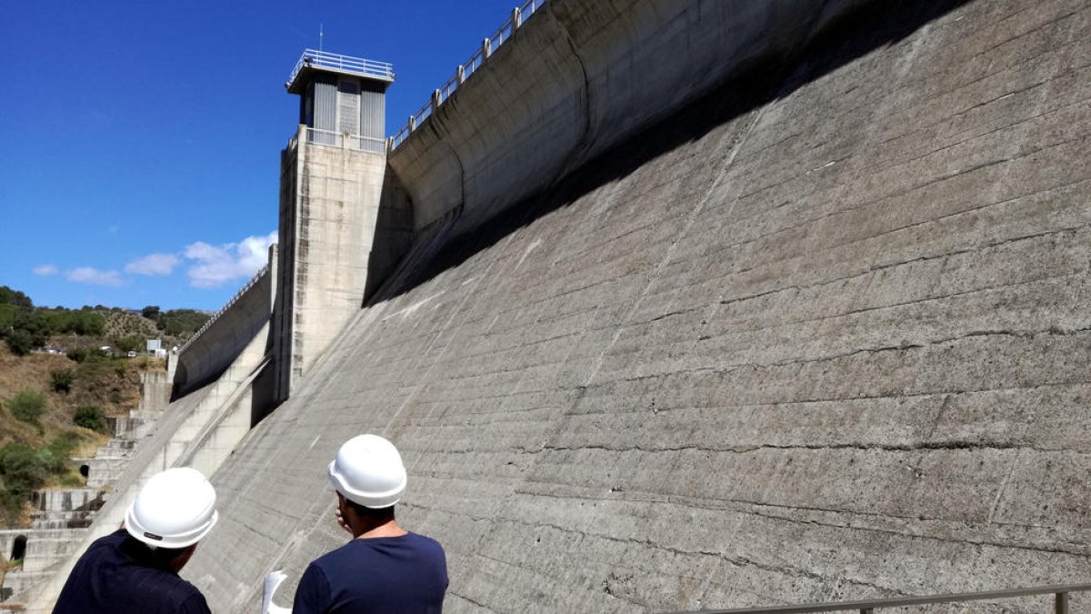 Plano medio dos operarios trabajando en las tareas de inspección de la presa del pantano de Siurana.