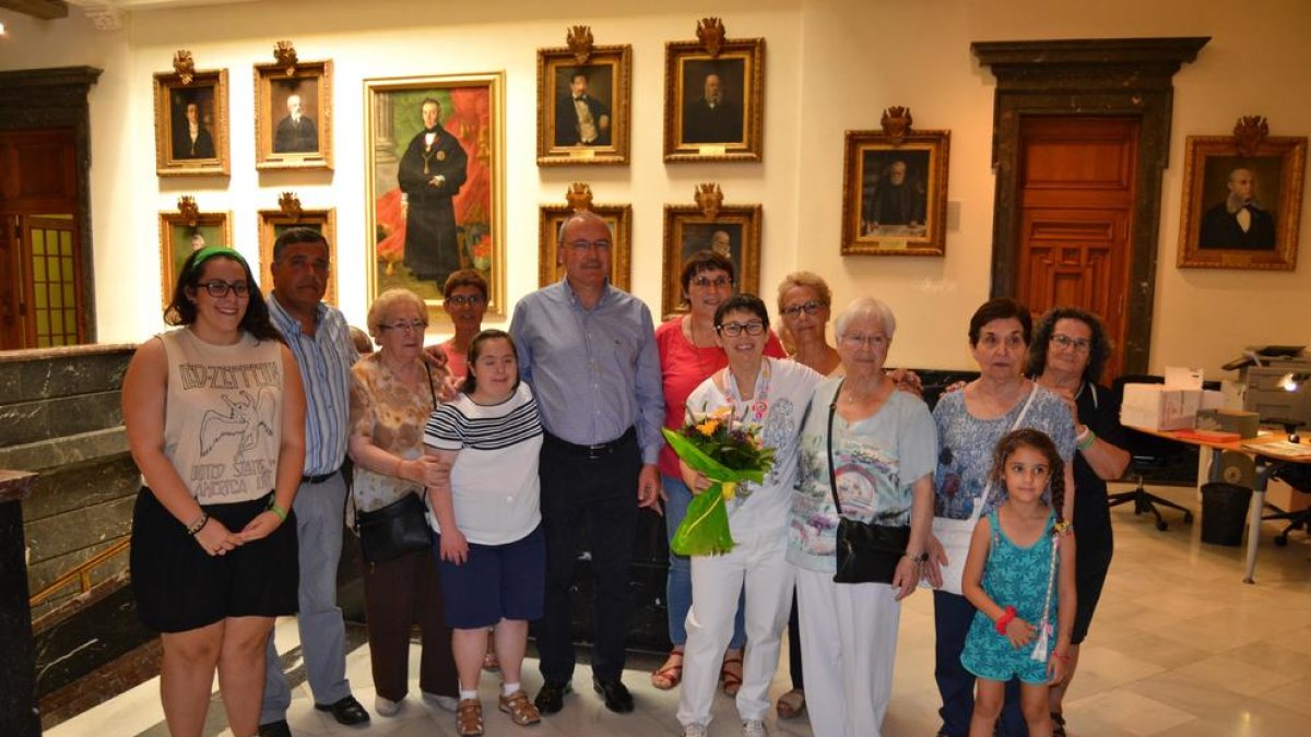 Fotografia de família de l'acte, on Pilar del Río sosté el ram de flors que se li ha regalat.