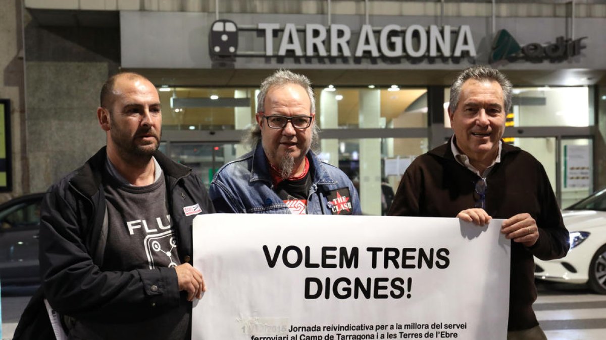 Carlos Montejano, José Tabuyo y Daniel Pi sostienen una pancarta pidiendo «trenes dignos».