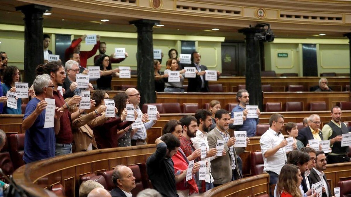 Los diputados de Podem, ERC y PDeCAT mostrando carteles de apoyo|soporte a Cuixart y Sànchez al Congreso.