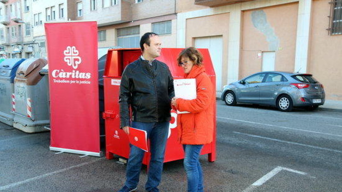 Plano general con el secretario general de Càritas Diocesana de Tortosa, Agustí Adell, y Marina Arnau, directora de la Fundación Formación y Trabajo en el Ebro y Tarragona, Delante de uno de los nuevos contenedores.