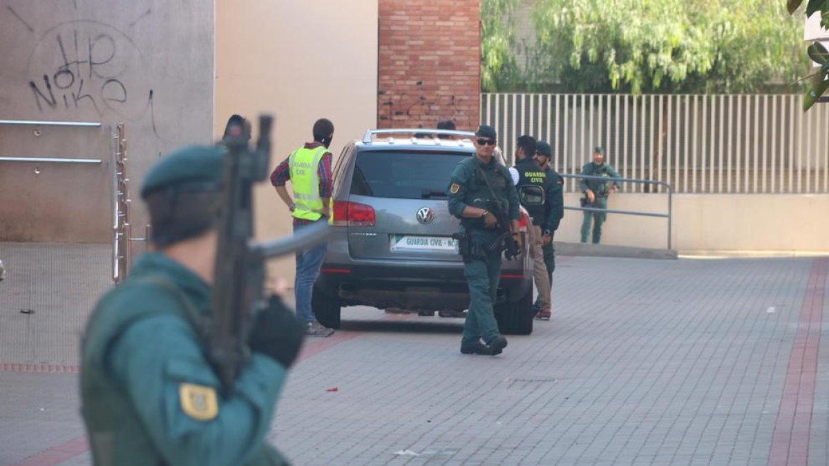 Imagen de varios efectivos de la Guardia Civil en Vinaròs, con un agente con arma larga, desenfocado y en primer término. Imagen del 22 de septiembre del 2017