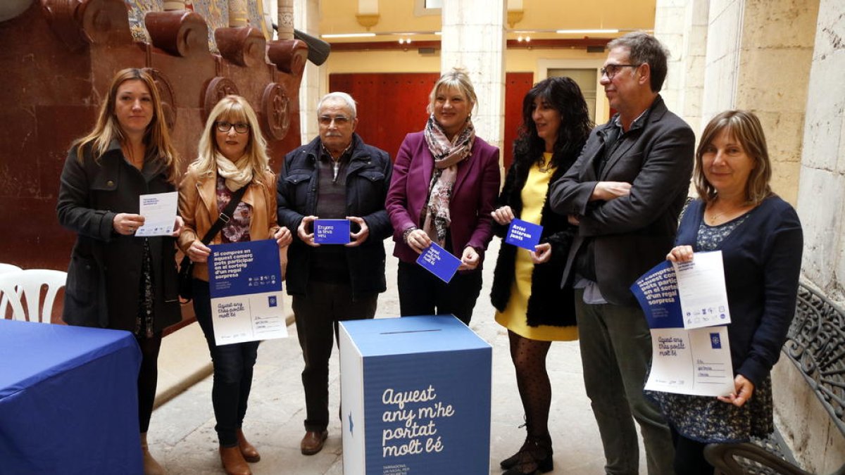 Plano general de la concejala de Comerç de l'Ajuntament de Tarragona, Elvira Ferrando, con representantes de asociaciones comerciales de la ciudad mostrando los materiales de la campaña navideña.