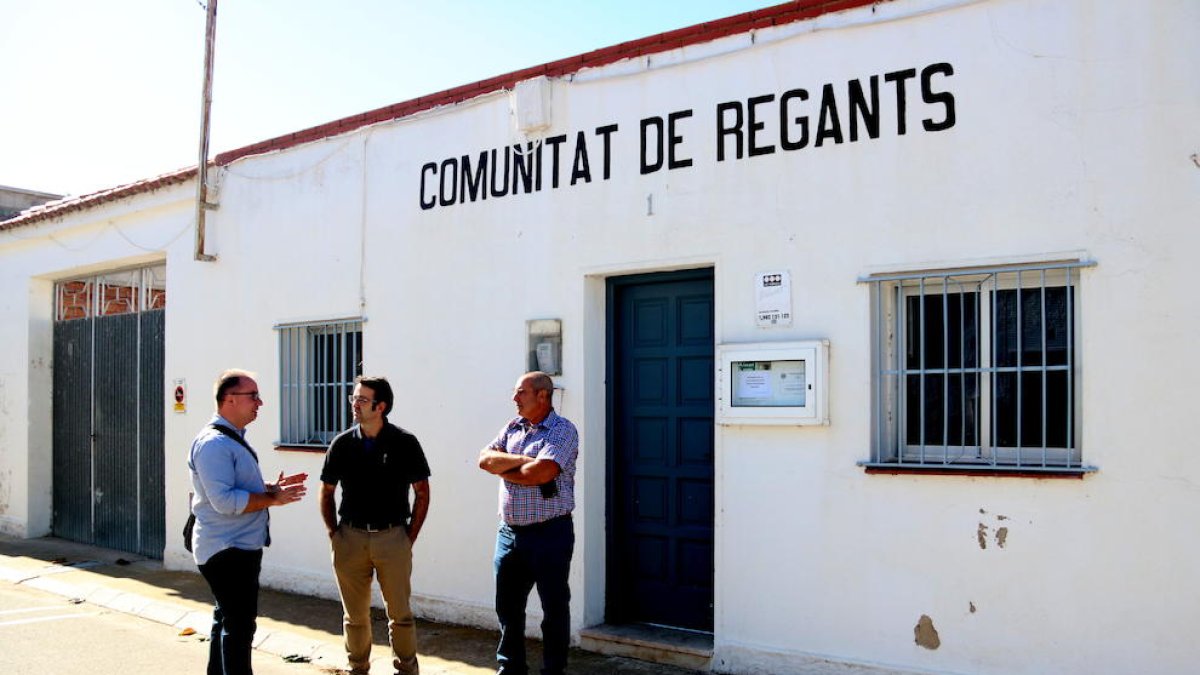 Imatge general del vicepresident de la Comunitat de Regants de Poble Nou, Josep Gilisbars, al centre, i el candidat crític, Jaume Roselló, a la dreta, amb l'assessor legal de la candidatura, davant la seu de l'entitat. Imatge del 23 d'octubre de 2017. (ho