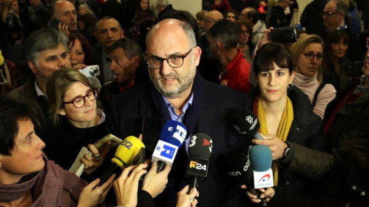 Imagen de Eduard Pujol atendiendo los medios de comunicación en el aeropuerto del Prat acompañado de otros miembros de la lista de JxCat.