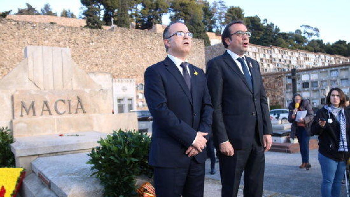 Els consellers destituïts Josep Rull i Jordi Turull canten 'Els Segadors' davant la tomba de Francesc Macià, en el seu homenatge al cementiri de Montjuïc, el 25 de desembre de 2017.