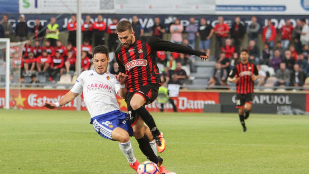 Benito, de roig-i-negre, pressionat per un jugador del Saragossa. El tarragoní és dubte per dissabte per un esquinç al turmell.