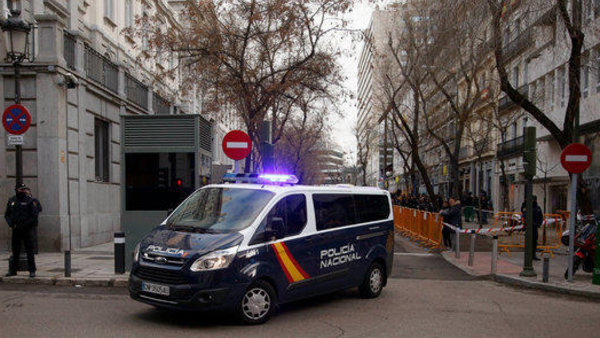 Pla mitjà de la furgoneta de la policia espanyola amb Jordi Sànchez gira cap al carrer del Tribunal Suprem.