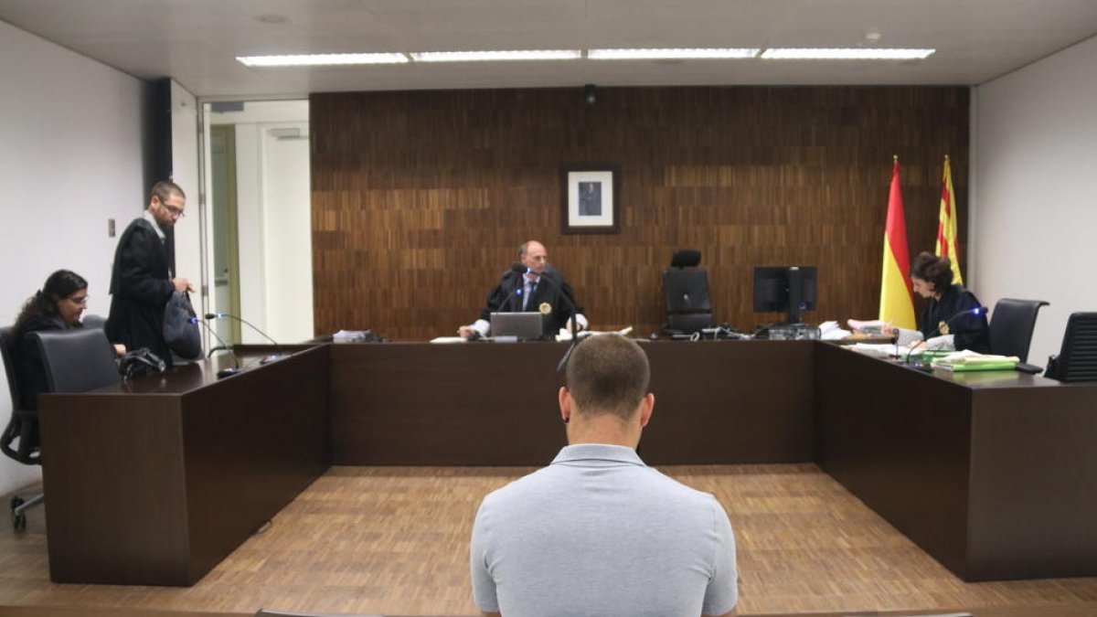 Plano medio de Andreu Curto, de espalda, sentado durante el juicio en la Ciudad de la Justicia.