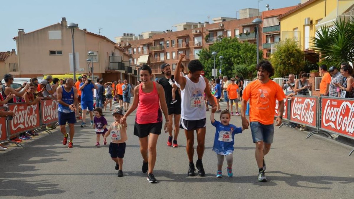 La pequeña Txell García, con camiseta azul, corriendo con su padre y su primo.