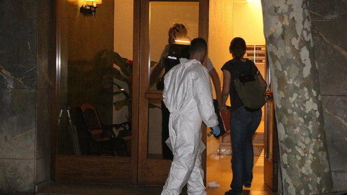 Dos agentes de la policía científica entrando en la vivienda de Vila-nova donde se encontró el cuerpo sin vida de la niña.