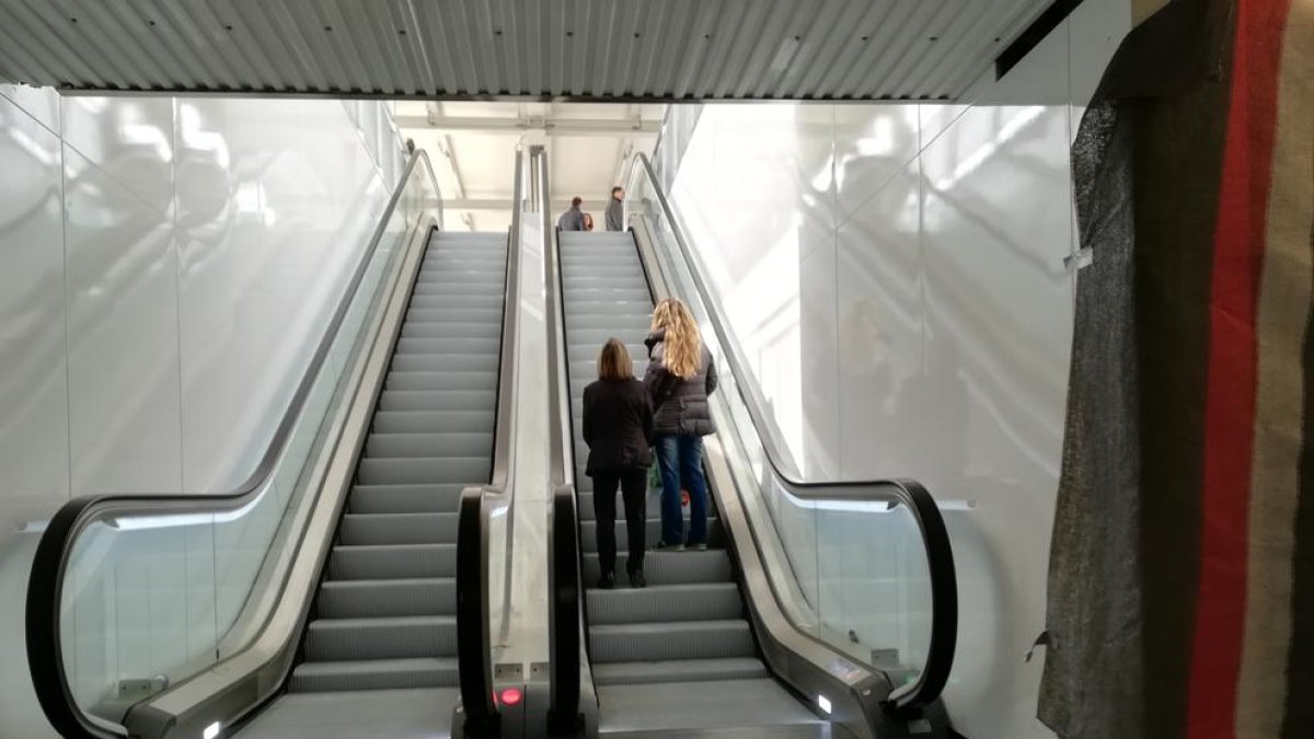 Dues persones ascendeixen en direcció a l'andana central de l'estació tarragonina.