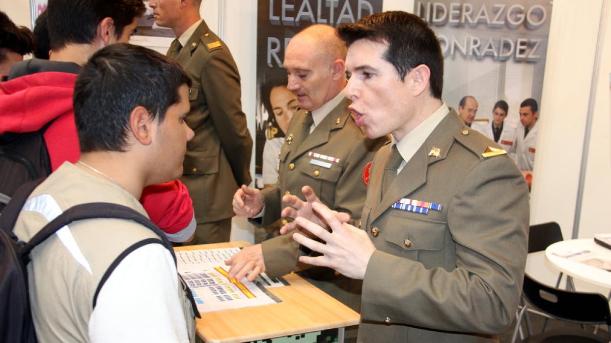 Un miembro del ejército explicando a un joven el funcionamiento del cuerpo en el stand del Expojove del 2017.