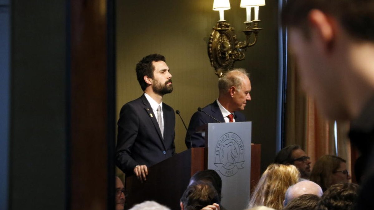 El president del Parlament, Roger Torrent, escolta les intervencions d'un col·loqui al Círculo Ecuestre amb el Cercle de Directius de Parla Alemanya, reflectit en un mirall al costat del seu president, Albert Peters