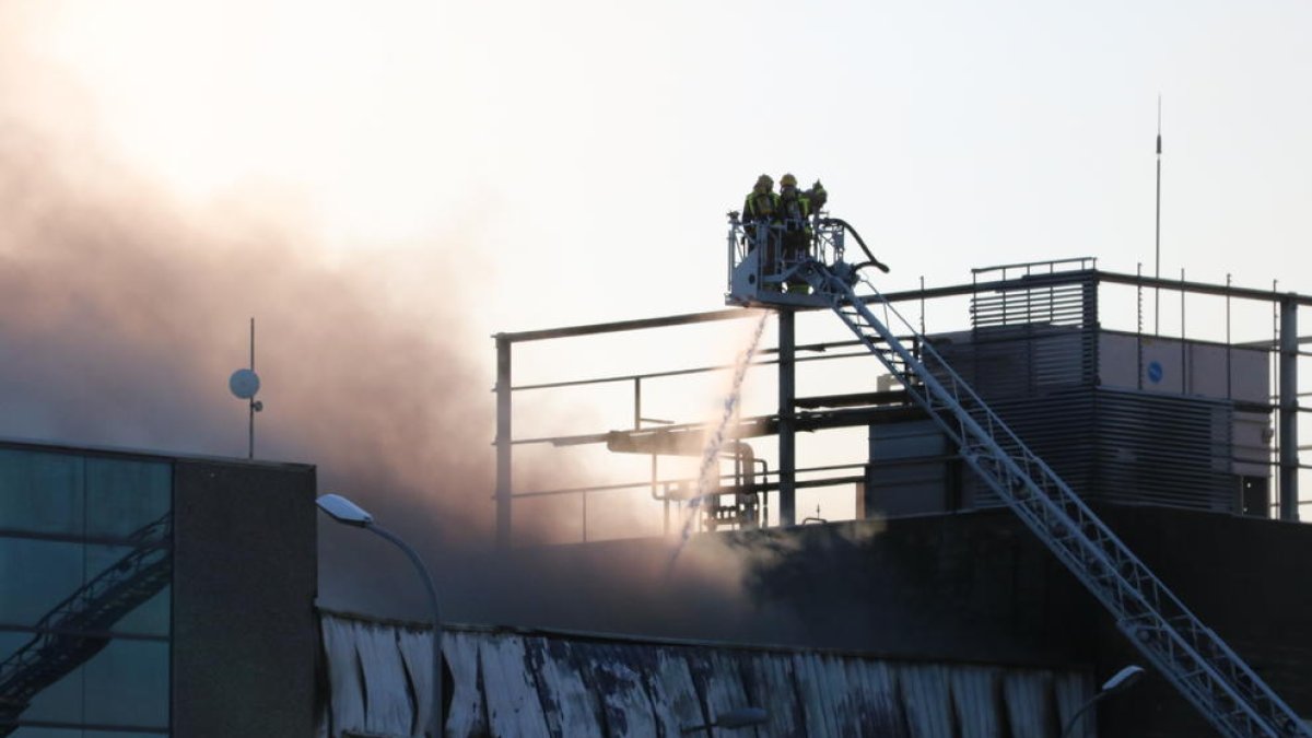Un equipo de bomberos ataca las llamas de una nave del grupo Balfegó incendiada el 22 de junio.