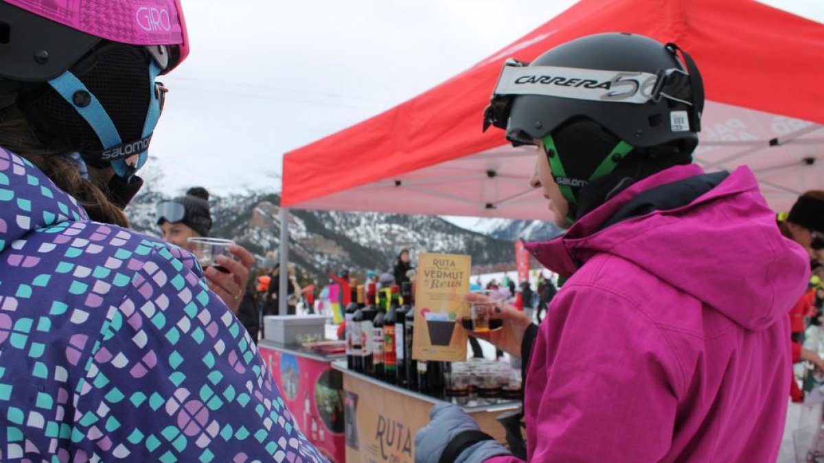 Dues esquiadores provant el Vermut de Reus a l'estació d'esquí