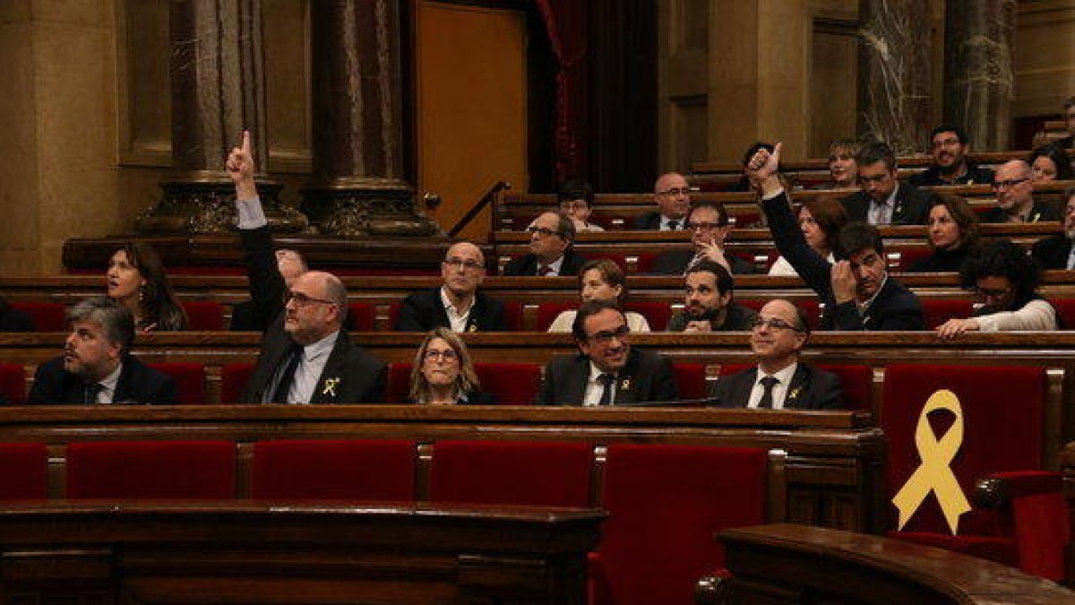 Imagen de Eduard Pujol, de JxCat, y Sergi Sabrià, de ERC, votando la propuesta de resolución que legitima Puigdemont, el 1 de marzo de 2018.