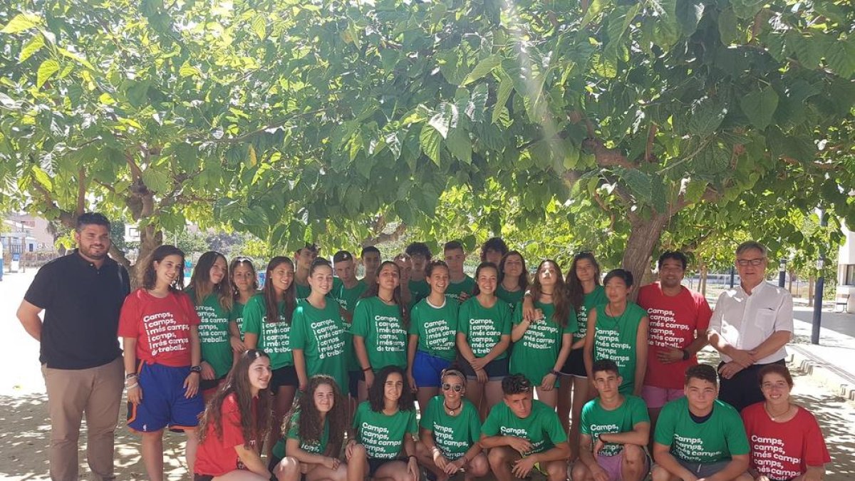 Imagen de los jóvenes participantes en el campo con los representantes municipales.