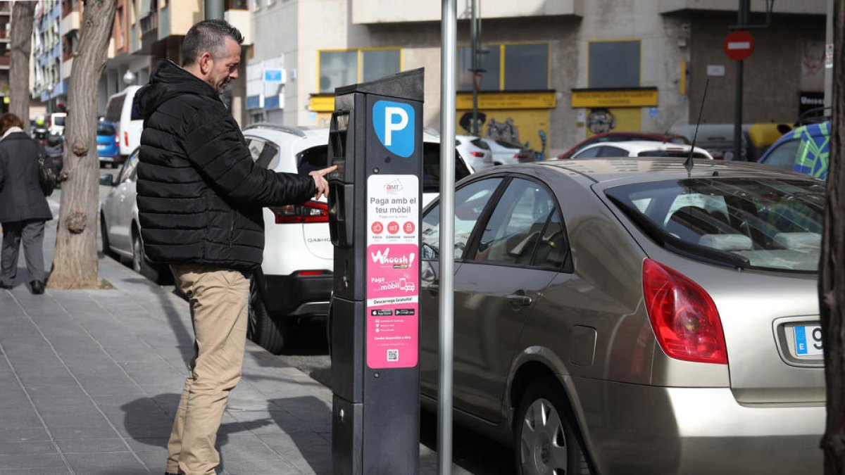 Un ciutadà paga a un dels parquímetres de la ciutat de Tarragona després d'aparcar a la zona regulada.