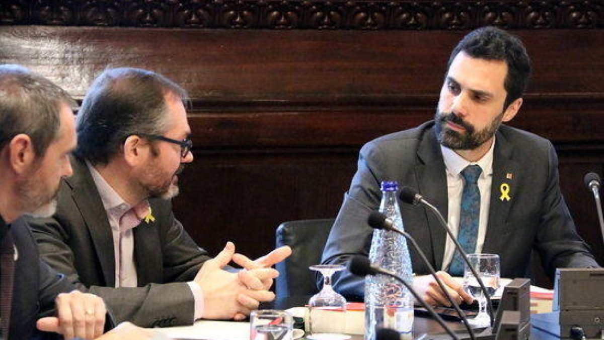 El president del Parlament, Roger Torrent, mira els diputats de JxCat Eusebi Campdepadrós i Josep Costa a la reunió de la Mesa, el 20 de febrer de 2018.