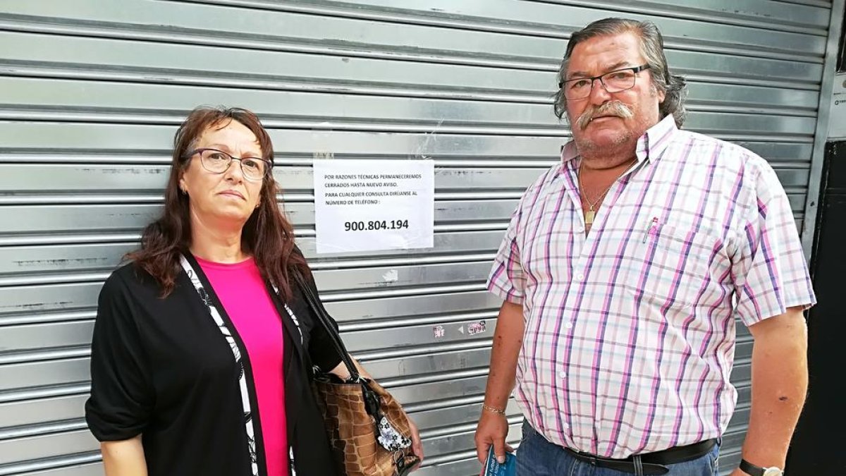 Els lleidatans María i Blas, ahir davant la porta tancada d'iDental i, al mig, el cartell on s'informava que no obrirà «fins a nou avís».