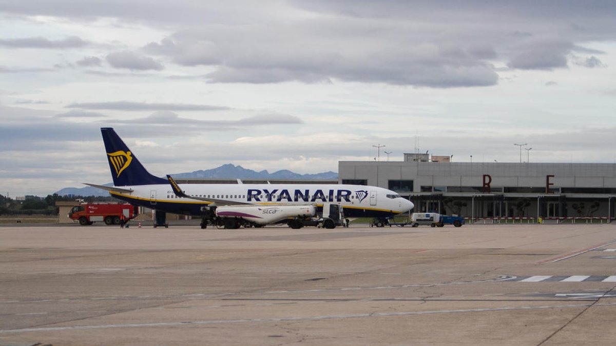 Pla general d'un avió de Ryanair al costat de la terminal de l'Aeroport de Reus.