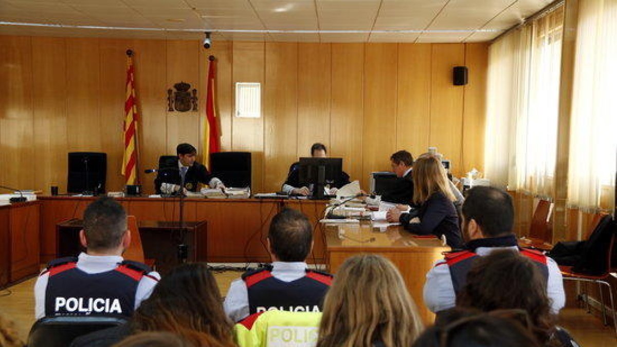 El público, agentes de los Mossos D'Esquadra y el magistrado, en el fondo, en el inicio del juicio en la Audiencia de Tarragona contra el hombre acusado de asesinar a una mujer en un piso de Valls.
