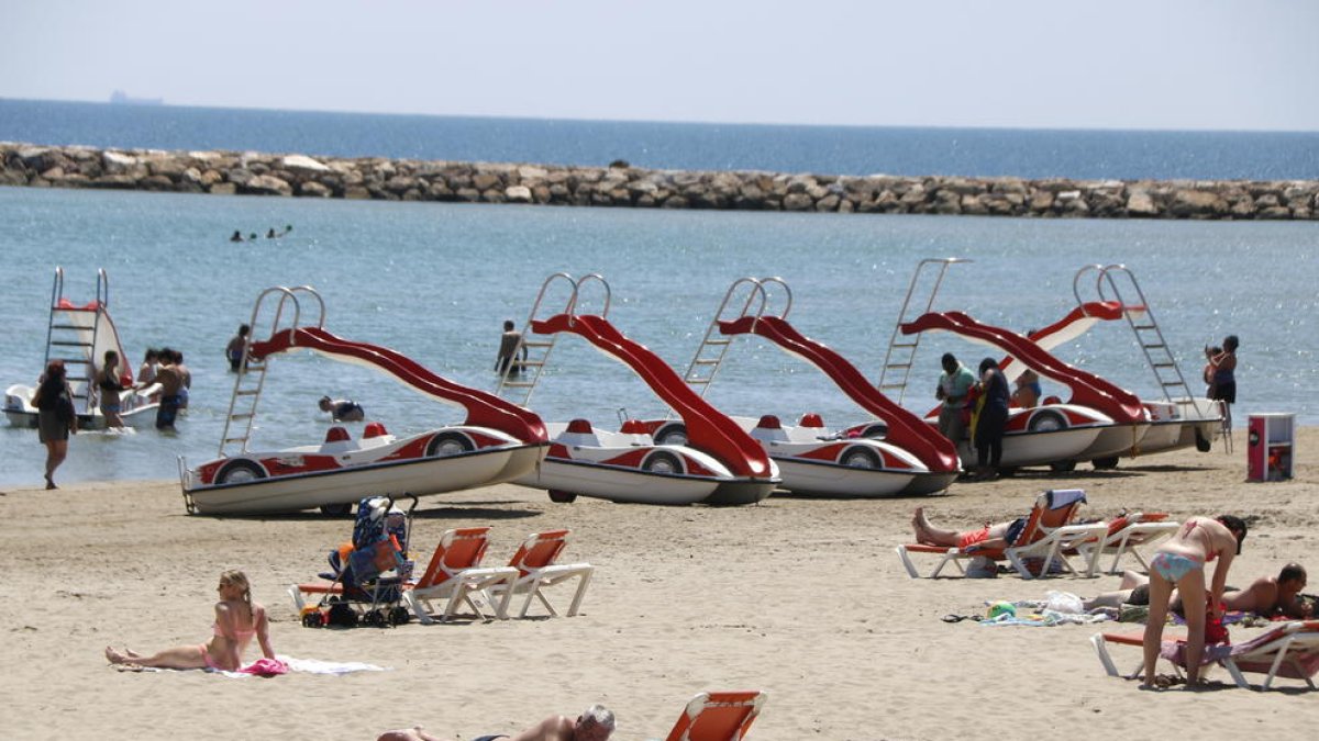 Plano abierto de bañistas y patinetes en la playa de la Pineda el 9 de mayo del 2018