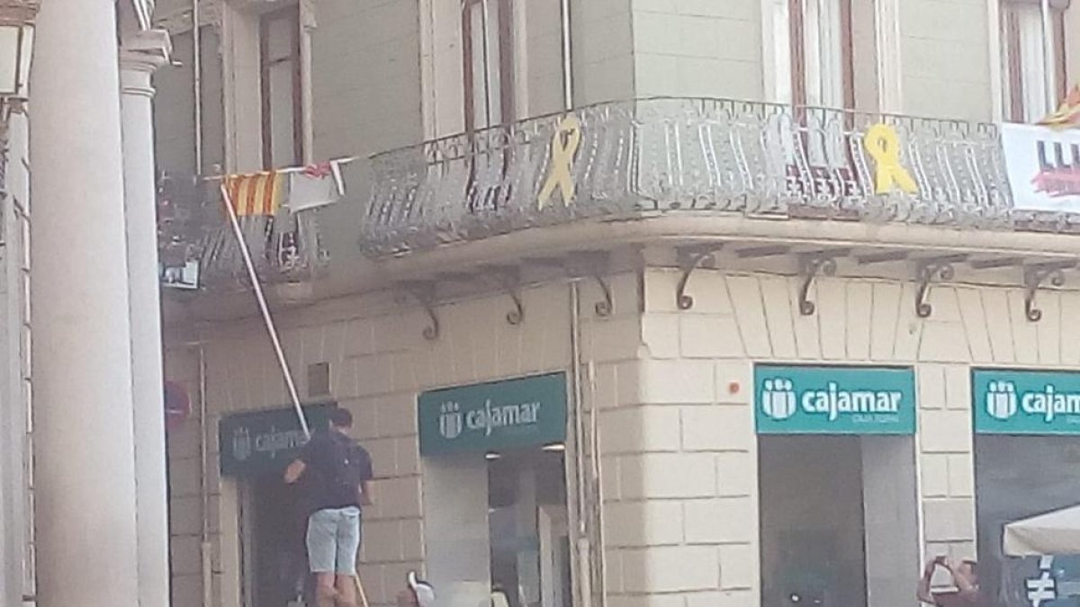Imatge dels individus traient la pancarta sobre els presos polítics de l'Ajuntament de Reus.