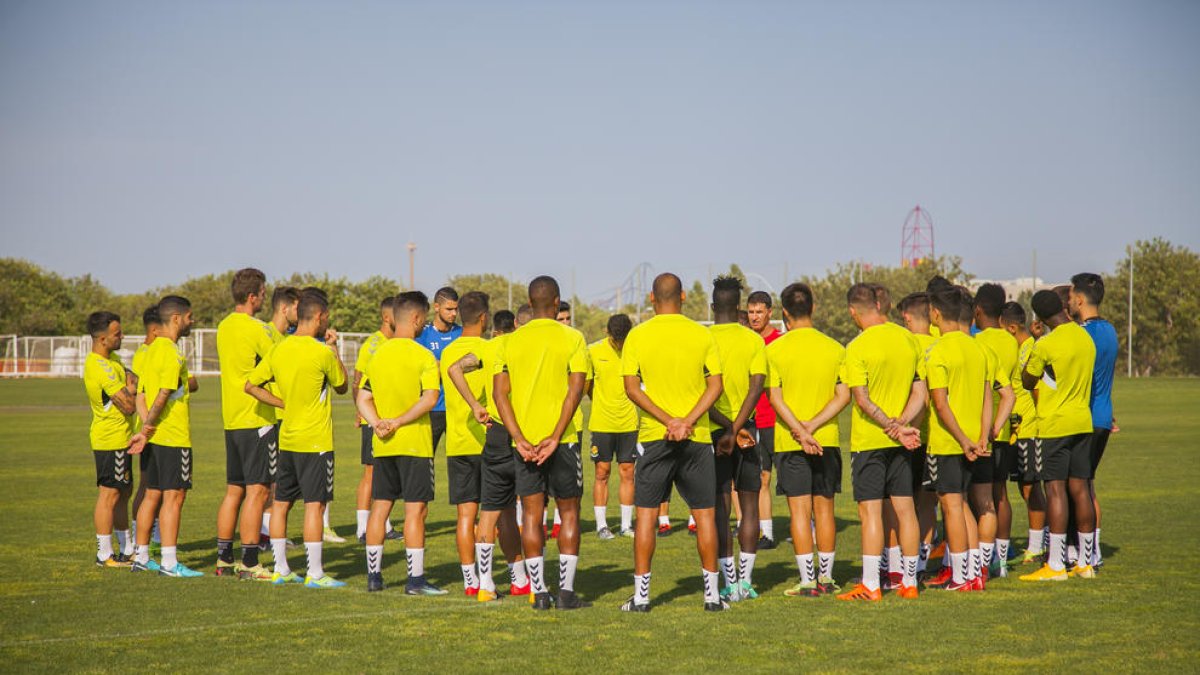 Els 33 futbolistes que es van exercitar a les ordres de Gordillo, seguint atentament les instruccions del seu entrenador a Salou.