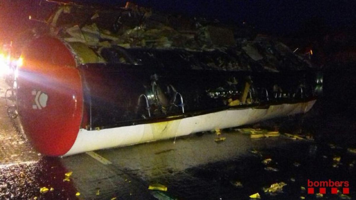 Imatge cedida pels Bombers d'una cisterna de camió bolcada després d'un accident a la N-340, a Alcanar (Montsià), el 9 de maig del 2018. Pla general