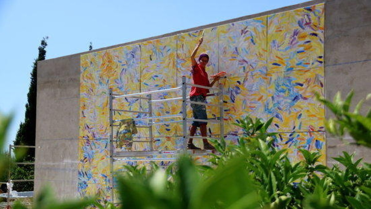 Vista general de la pintora Ursula Jüngst trabajando en su cuadro 'La fiesta de la vida' en su taller al aire libre.