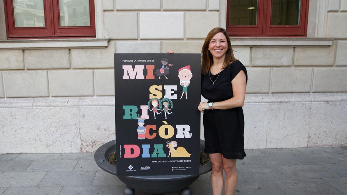 Laia Arriols, dissenyadora del cartell de les Festes de Misericòrdia 2018, junt a la seva creació.