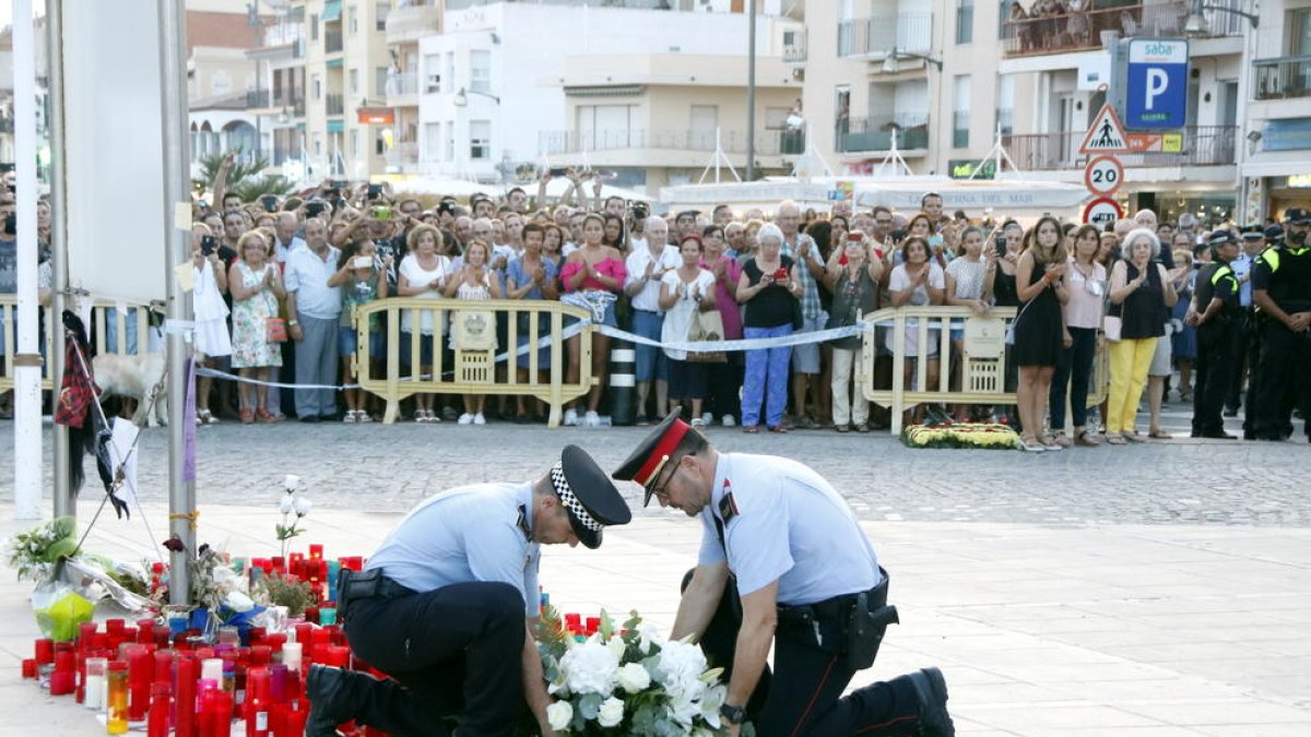 Imatge d'arxiu de l'ofrena floral d'un mosso d'esquadra i un agent de la Policia Local de CAmbrils