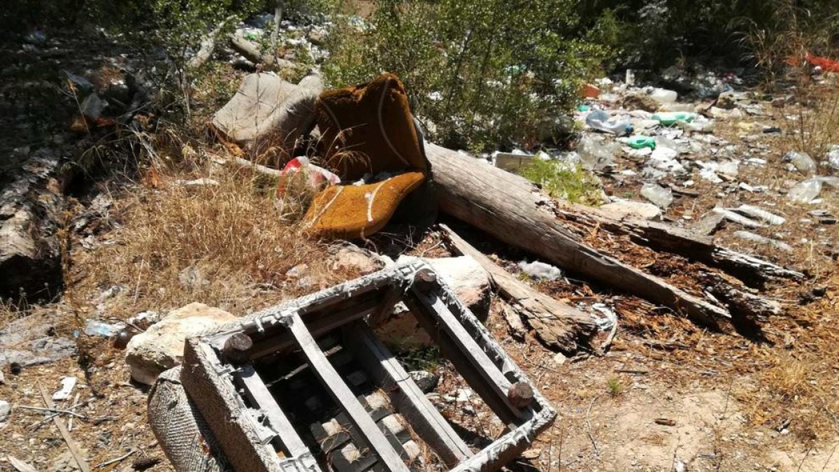 Restos de lo que queda de una butaca, a pocos metros de material de todo tipo abandonado a tierra.