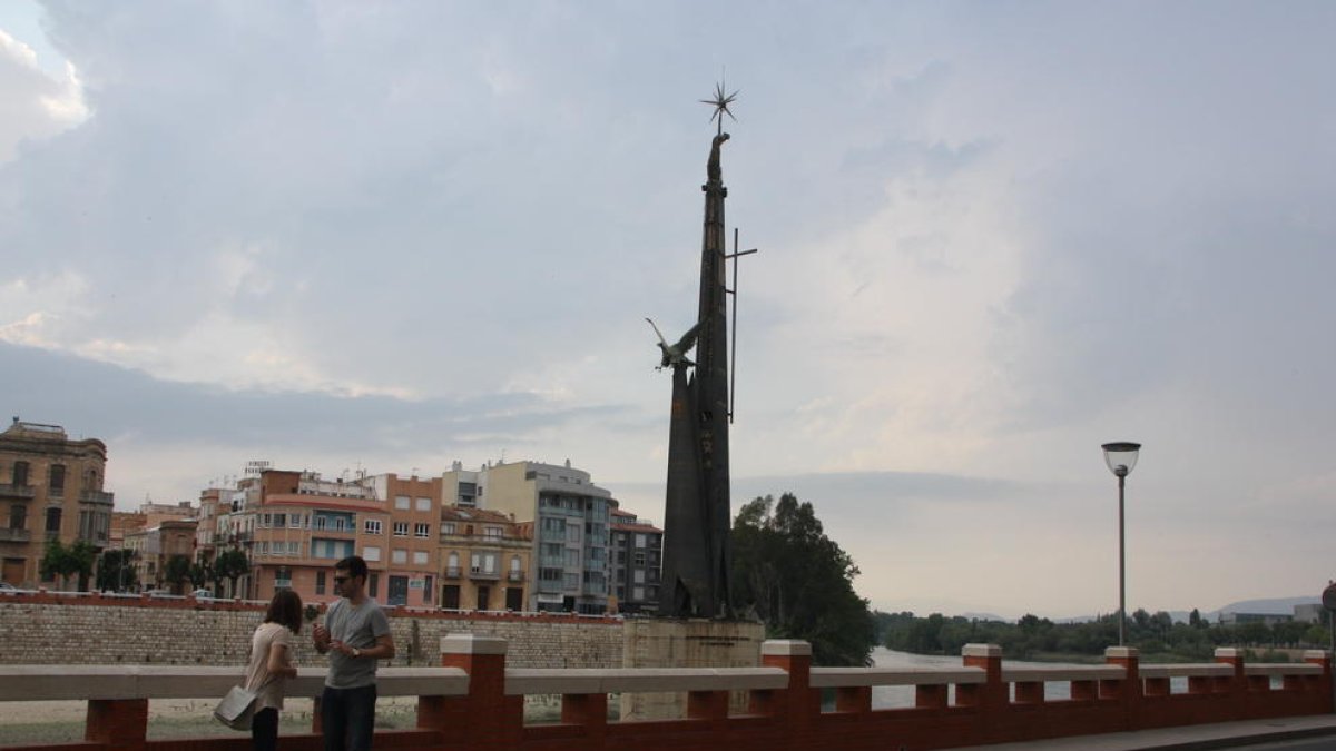 Una pareja se fotografía delante del monumento franquista de Tortosa.