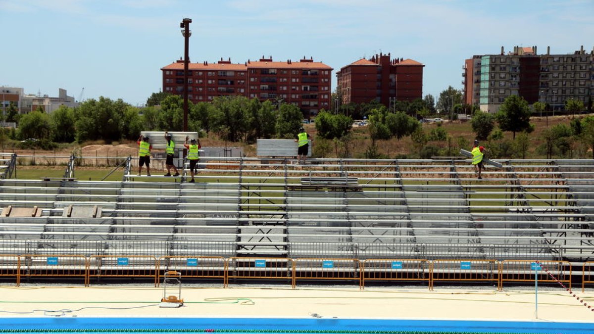 Els operaris instal·lant les graderies efímeres de la piscina dels Jocs Mediterranis de Tarragona.