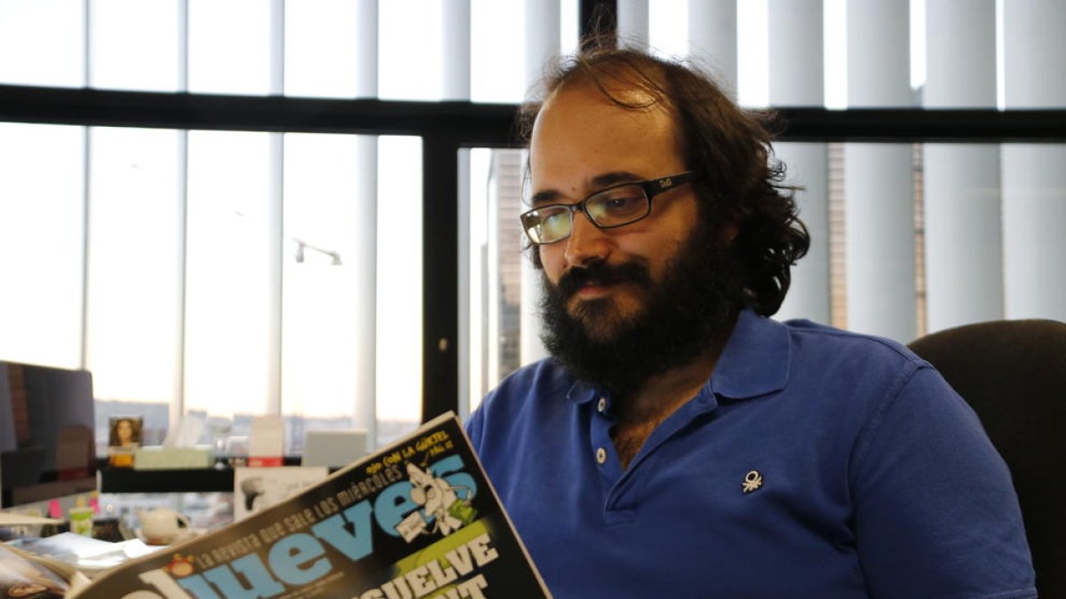 El director de la revista satírica 'El Jueves', Guille Martínez, llegint un exemplar.