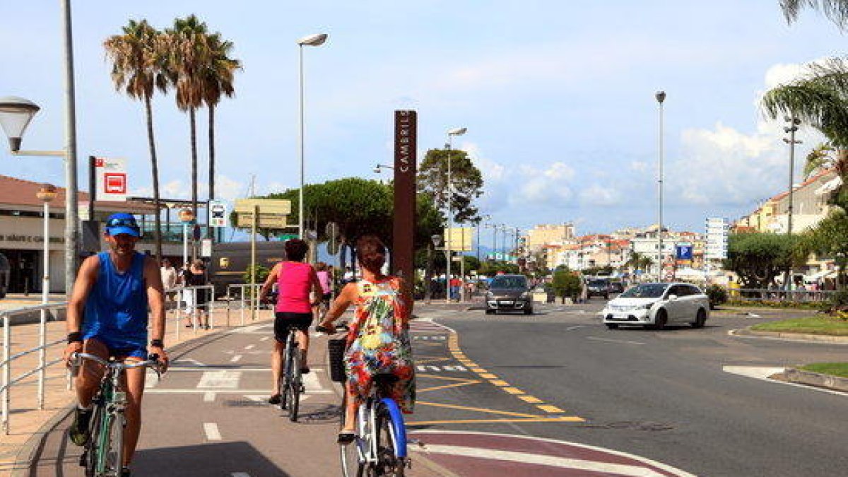 Turistas en bicicletas en el Paseo Marítimo de Cambrils donde se produjo el atentado terrorista ahora hace un año.