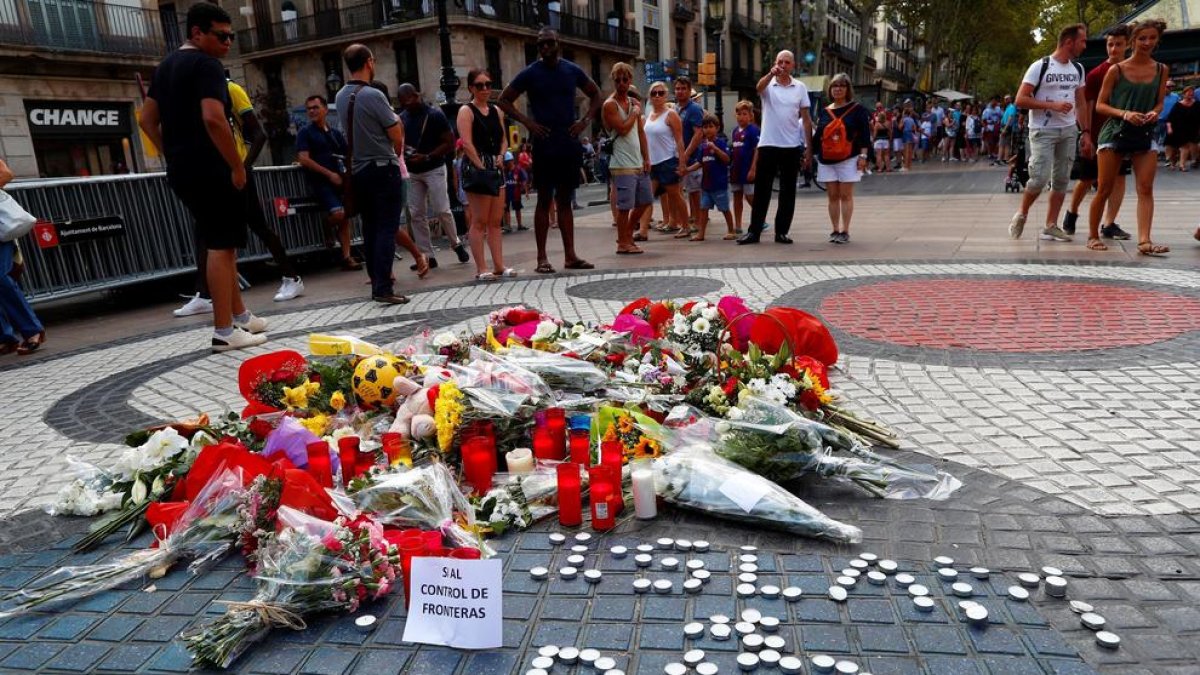 Ramos de flores y objetos de todo tipo depositados en el mural de Miró de la rambla de Barcelona en recuerdo a las víctimas de los atentados.
