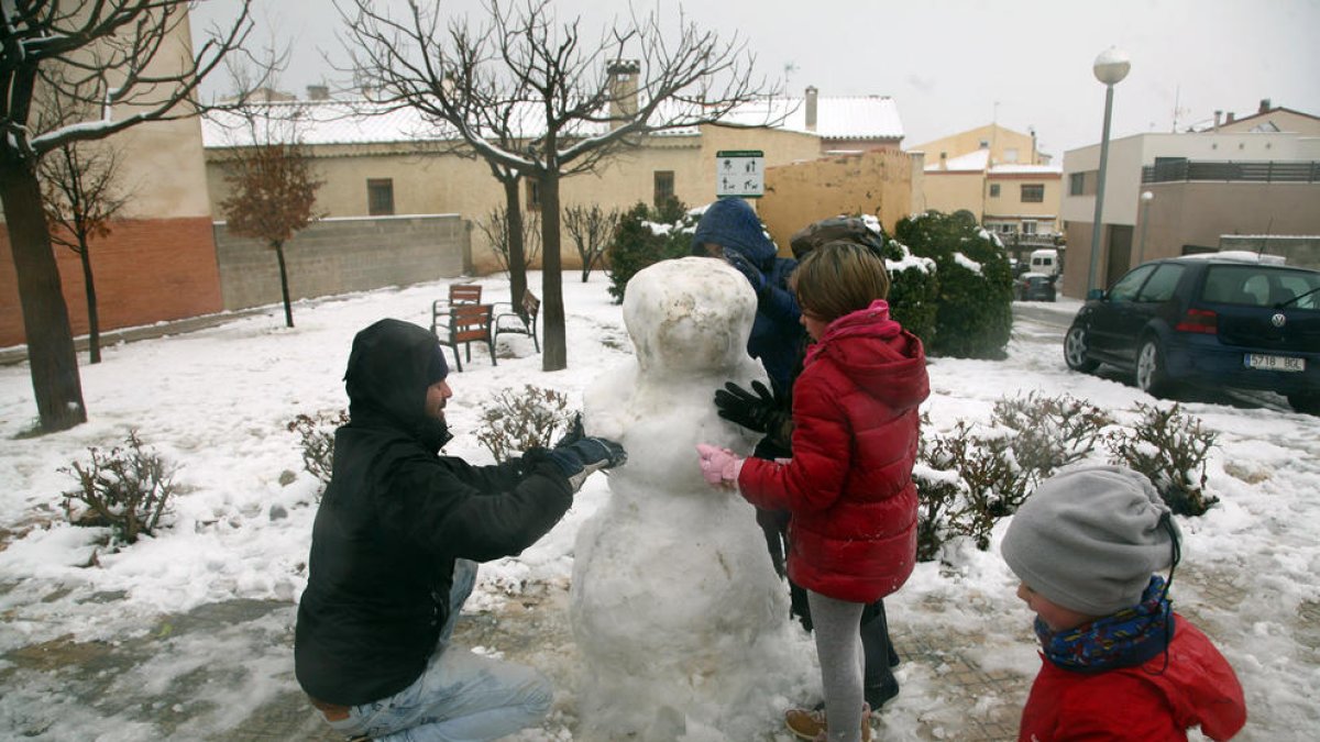 Infants fent un ninot de neu a l'Espluga de Francolí.