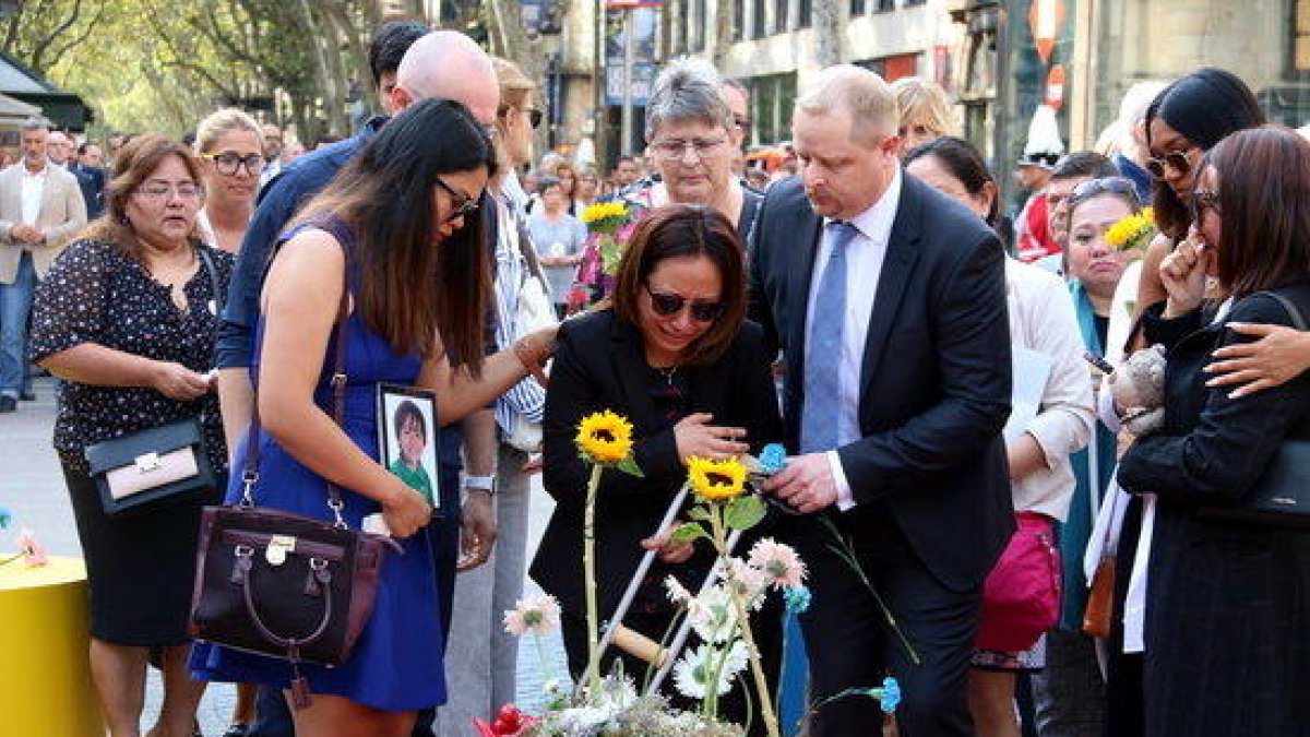 Familiares de las víctimas de los atentados del 17-A haciendo la ofrenda floral en el mosaico de Joan Miró de la Rambla de Barcelona.