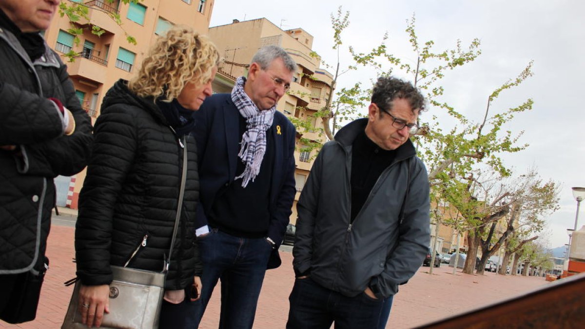 Pla mig de l'alcaldessa de Tortosa, Meritxell Roigé, llegint un dels plafons instal·lats al costat d'un pont.