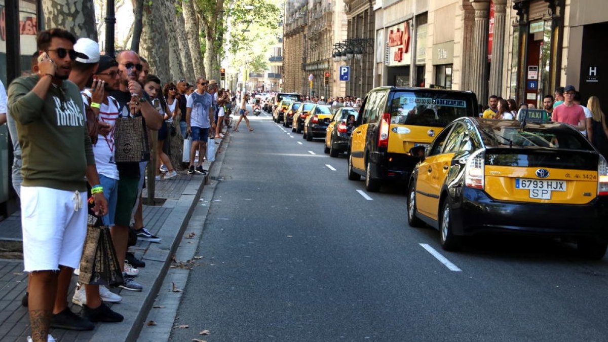 Taxis baixant per la Rambla en marxa lenta, en solidaritat amb les víctimes dels atemptats del 17-A.