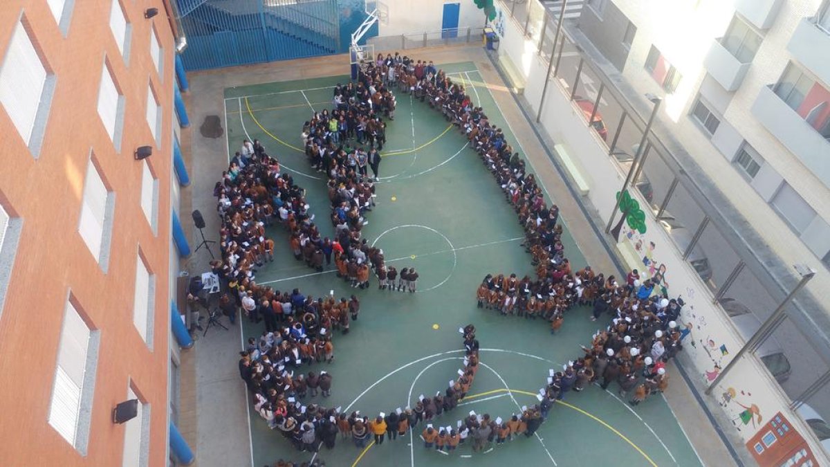 Alumnes i professors van formar un colom de la pau al pati de l'escola.