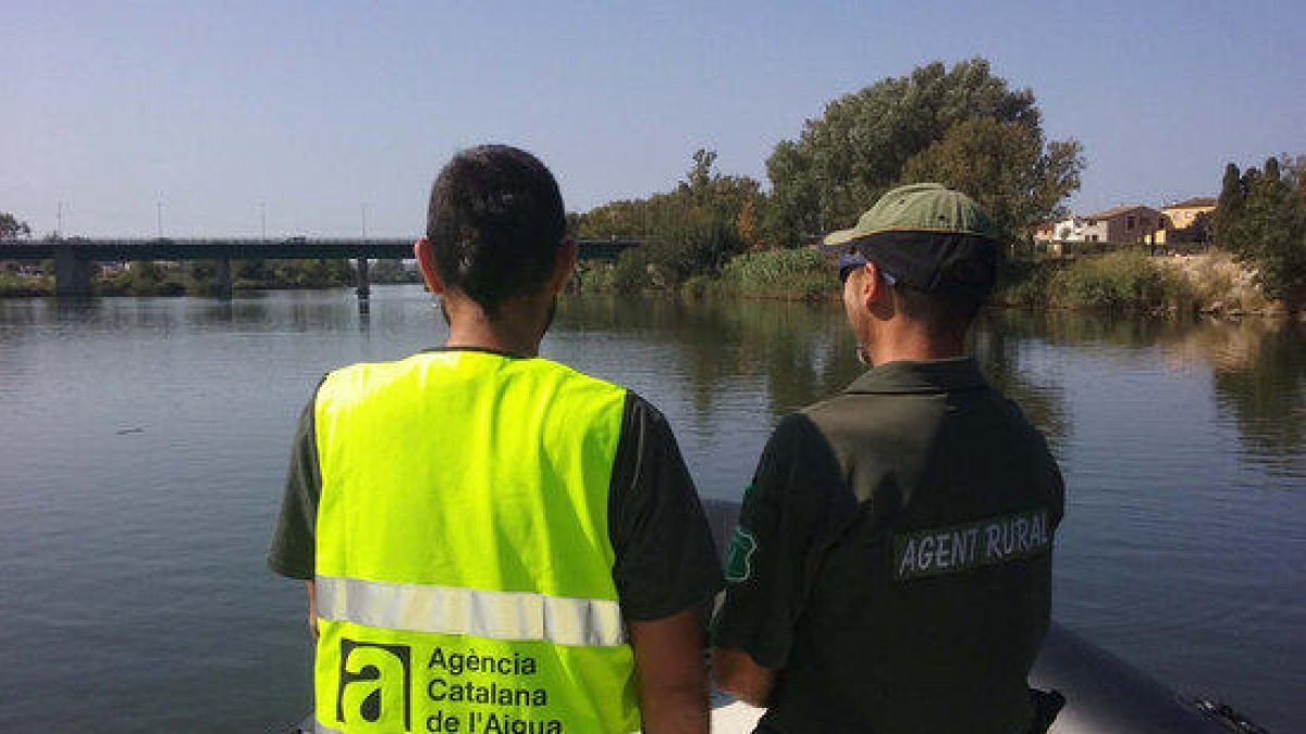 Plano medio de un técnico del ACA y un Agente Rural recorriendo el río Ebro con una embarcación.