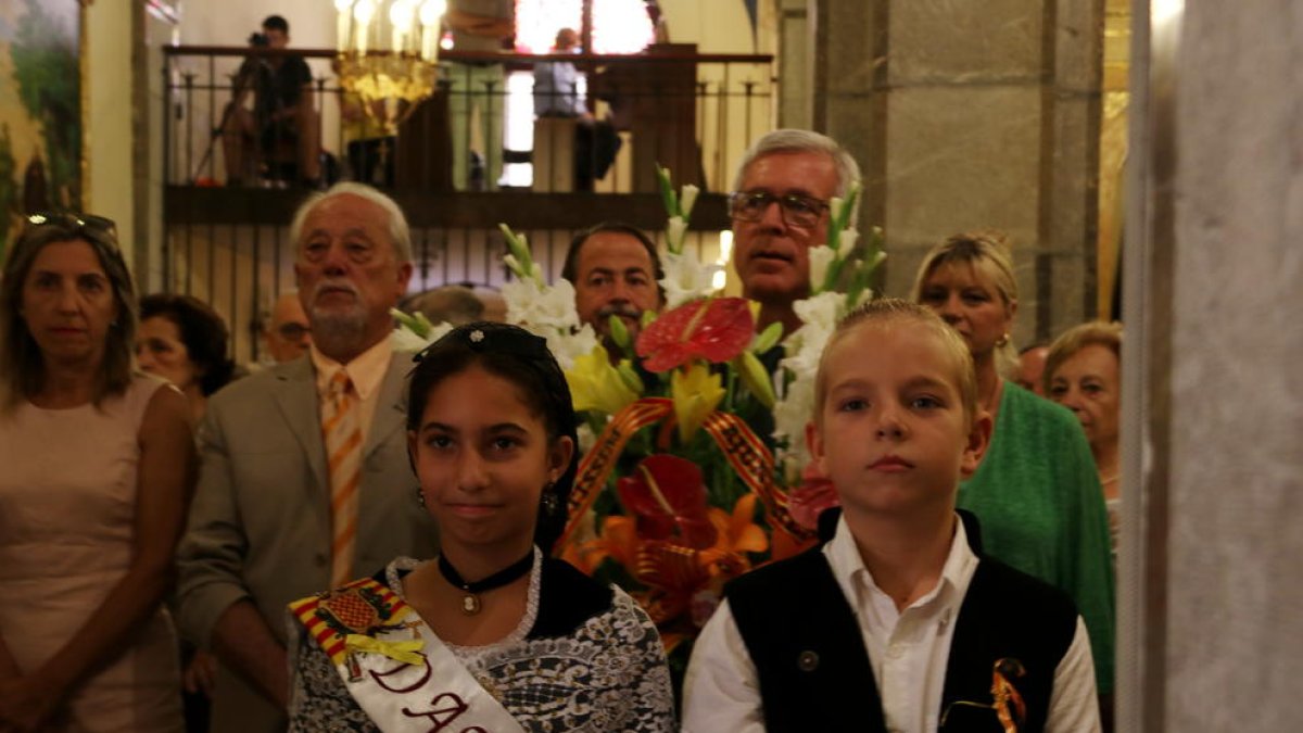 Pla mig de dos infants en primer terme i de l'alcalde Josep Fèlix Ballesteros en el moment de l'ofrena floral a Sant Magí.