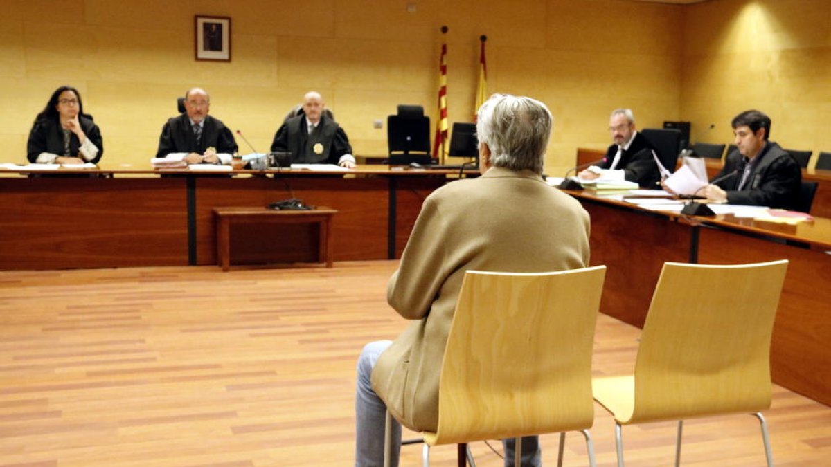 D'esquenes, l'acusat d'agredir sexualment la neta a Riells i Viabrea durant el judici a l'Audiència de Girona.