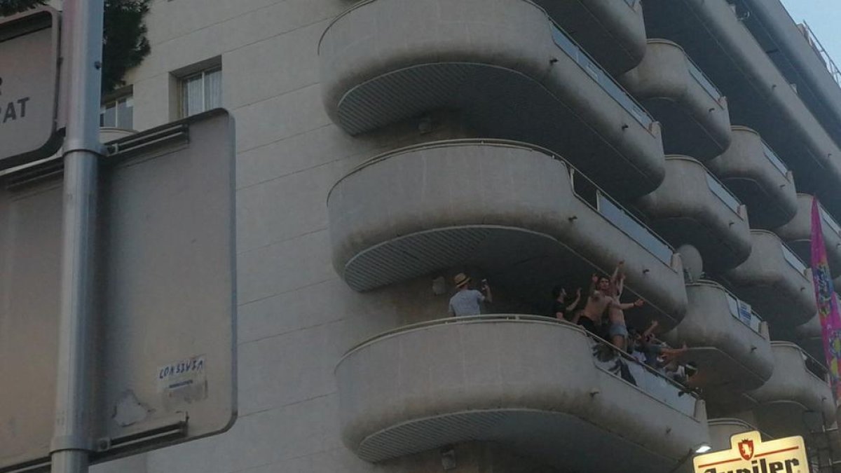 Grup de joves turistes, en posició perillosa, en un balcó de Salou, la setmana passada.